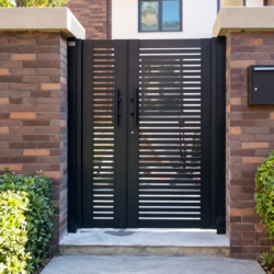 Double-leaf aluminium slat garden gate between brick posts
